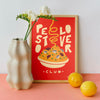Affiche murale design Pastielle Pesto Lover – affiche représentant un plat de pâtes sur fond orange, cadre posé dans une cuisine rose avec des citrons et un vase blanc
